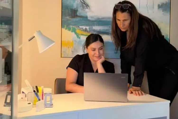 Two women reviewing health data together on a laptop at the Wellness Architecture clinic
