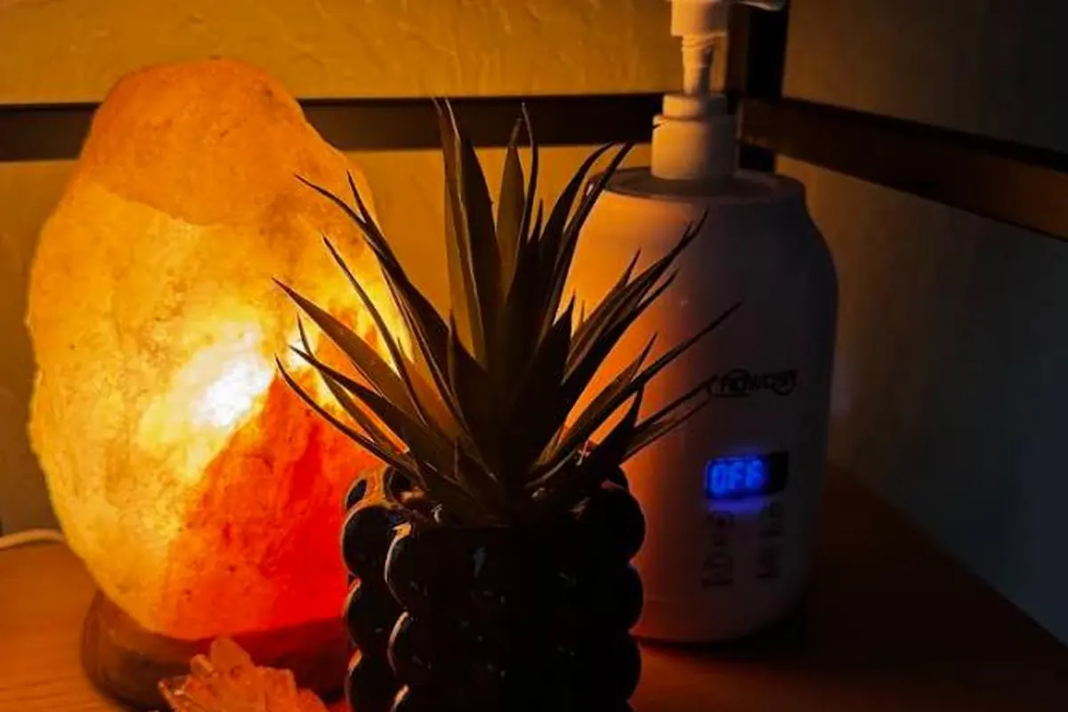 A softly lit salt lamp and humidifier at the bedside